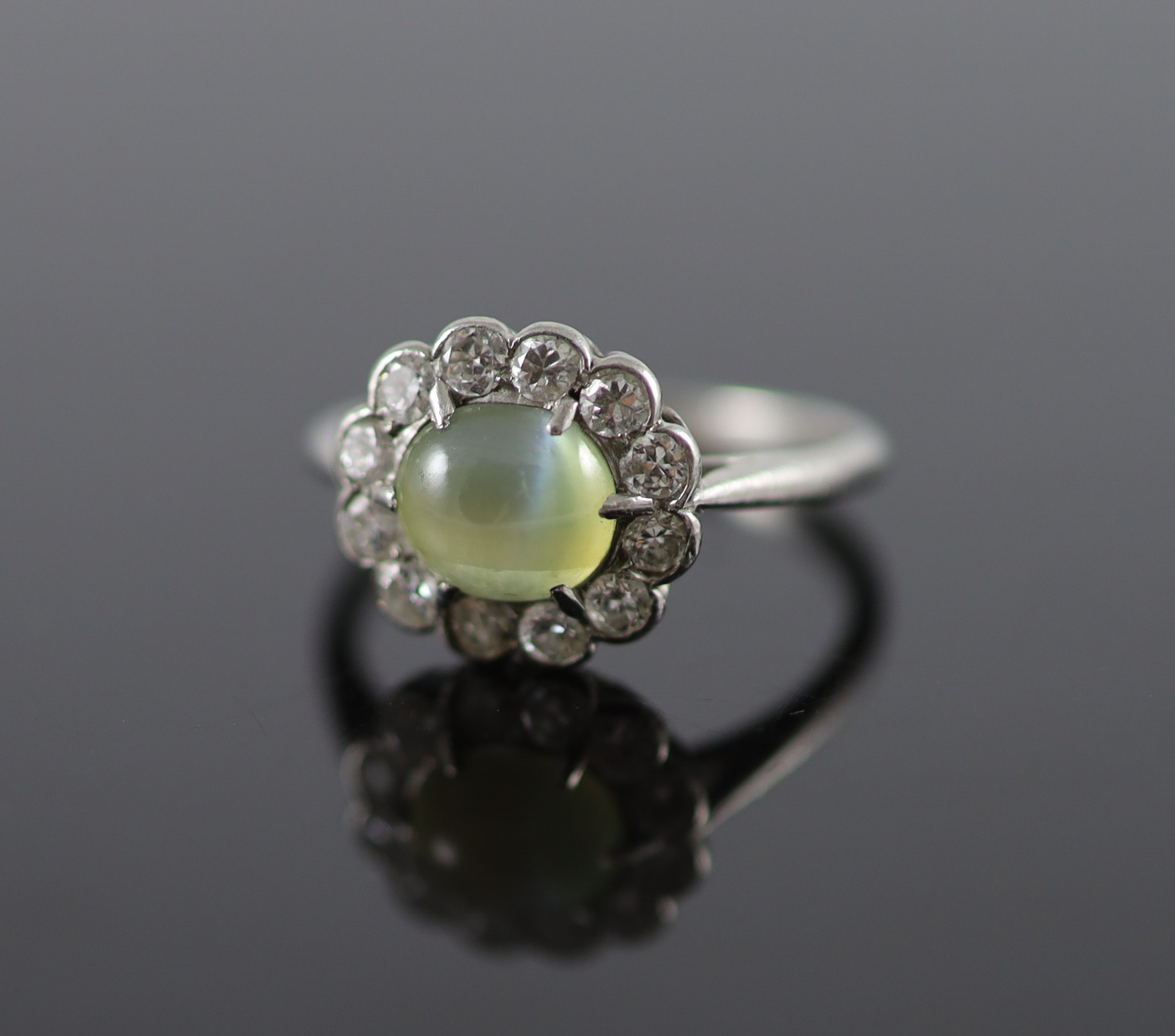 A 1920's/1930's platinum, cats eye chrysoberyl and diamond set oval cluster ring